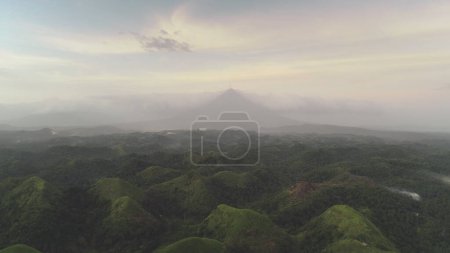 Campo verdes colinas en el día nublado. Niebla Haze sobre monturas gamas en exuberante vegetación. Nadie paisaje natural tropical de la ciudad de Legazpi, Filipinas, Asia. Dramática niebla paisaje rural plano aéreo