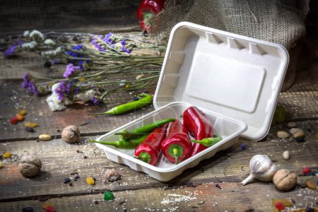 Téléchargez les photos : Vegetables in a container in an eco-friendly disposable bowl on a wooden background - en image libre de droit