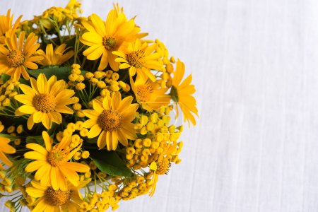 Bouquet von leuchtend sonnigen gelben Blumen auf einem leichten pastellfarbenen Hintergrund