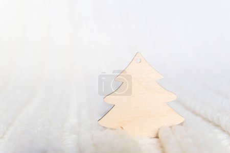 Photo for Wooden Christmas tree for your text on a white knitted background - Royalty Free Image