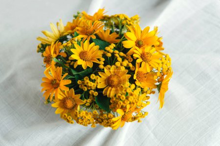 Bouquet von leuchtend sonnigen gelben Blumen auf einem leichten pastellfarbenen Hintergrund