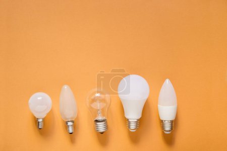 Foto de Cinco bombillas diferentes sobre fondo naranja - Imagen libre de derechos