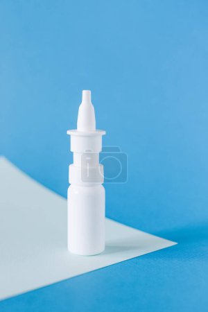 Foto de Aerosol nasal. Botella de medicina blanca maqueta sobre fondo azul, sin diseño de etiqueta, espacio de copia - Imagen libre de derechos