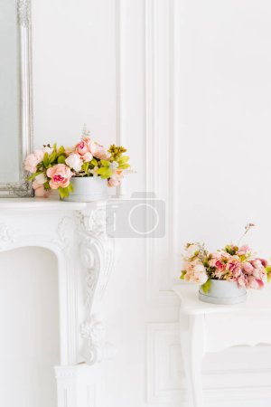 Foto de Decoración suave para el hogar, jarrón con hermosas flores blancas y amarillas sobre un fondo de pared blanco y sobre una mesa blanca. Interior. - Imagen libre de derechos
