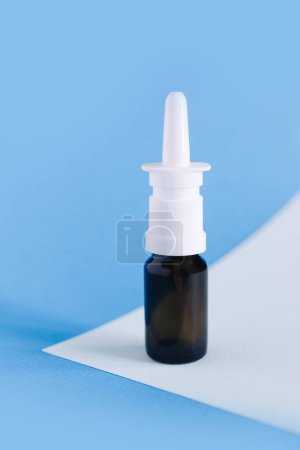 Foto de Aerosol nasal. Botella de medicina marrón maqueta en fondo azul, sin diseño de etiqueta, espacio para copiar - Imagen libre de derechos