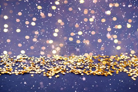 Festive blue background with confetti stars bokeh lights. Holiday concept on blue background. Flat lay, top view, copy space. Birthday, wedding, party and christmas.