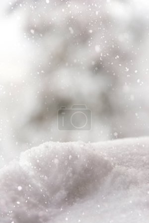 Photo for Winter bright snowy background. New Year's landscape with snowdrifts and snowflakes. Selective focus. Vertical photo. - Royalty Free Image