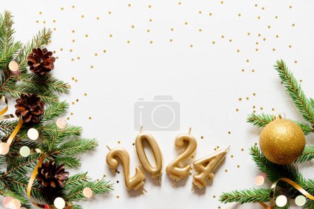 Foto de Banner de tarjeta de Navidad con ramas de árbol de Navidad y números de vela de oro 2024, cinta decorativa dorada, conos y estrellas. Fondo claro. Burlarse. Feliz año nuevo marco. - Imagen libre de derechos