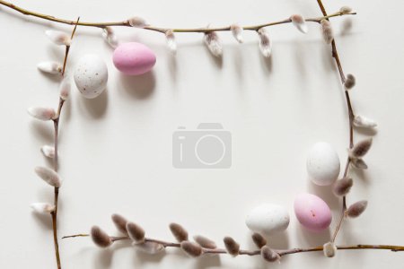 Foto de Composición de Pascua con una rama de sauce y huevos blancos de codorniz sobre un fondo gris claro. Concepto de vacaciones de primavera y Pascua con espacio para copiar. Vista superior, Piso tendido - Imagen libre de derechos