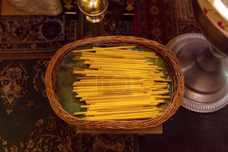 Téléchargez les photos : Ensemble de bougies jaunes dans un panier de l'église - en image libre de droit