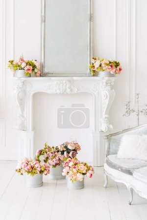 Téléchargez les photos : Soft home decor, decorative fireplace, vases with flowers and mirror. White wall background, Interior. - en image libre de droit
