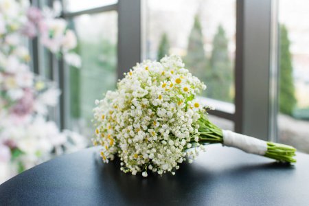 Téléchargez les photos : Bouquet de marguerites de fleurs de printemps sur la table. Bouquet de mariée - en image libre de droit