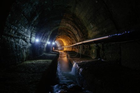 Téléchargez les photos : Undergound vaulted urban sewer tunnel with dirty sewage. - en image libre de droit