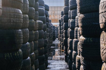 Foto de Stack of tires for sale in warehouse. - Imagen libre de derechos