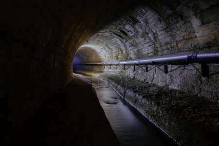 Foto de Underground vaulted urban sewer tunnel with dirty sewage. - Imagen libre de derechos