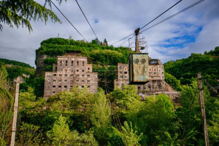 Old rusty cable car and overgrown abandoned factory in Chiatura, Georgia.