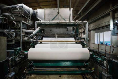 Téléchargez les photos : Usine de recyclage des déchets de papier. Machine pour la production de rouleaux de papier. - en image libre de droit