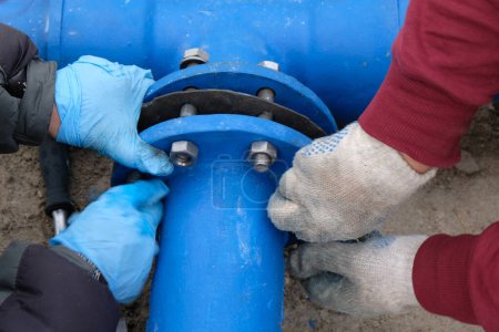 Foto de Trabajadores instalando sistema de tuberías de suministro de agua, de cerca. - Imagen libre de derechos