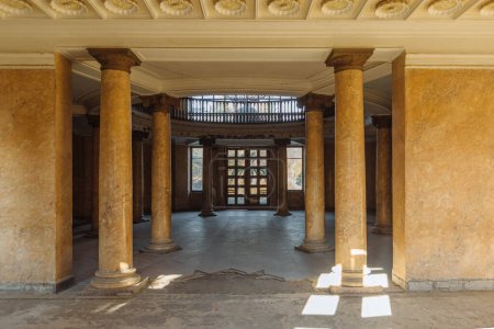 Hall de entrada con columnas en antigua mansión abandonada.