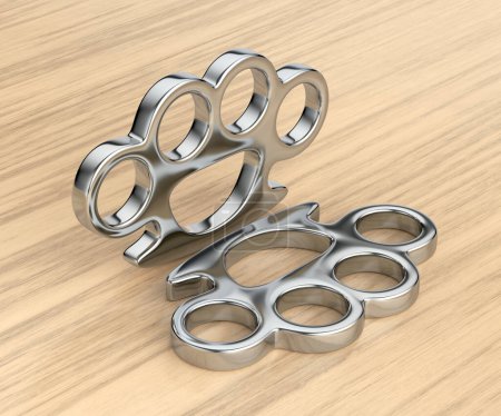 Pair of brass knuckles on wooden table