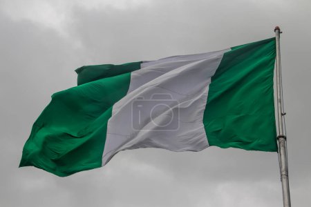 Nigerian flag, with three vertical bands of green, white, green. The two green stripes represent natural wealth, and the white represents peace and unity