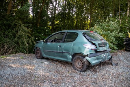 Vehículo dañado en accidente de tráfico estacionado en el estacionamiento, esperando ser fijado en taller mecánico