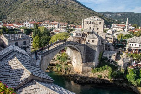 Photo for View of Stari Most (old bridge) in Mostar Village with Neretva River, Bosnia Herzegovina, 16th-century Ottoman bridge in the city of Mostar in Bosnia and Herzegovina that crosses the river Neretva and connects the two parts of the city - Royalty Free Image