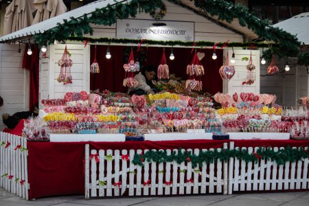Foto de Colorida y atractiva tienda de dulces callejeros llena de dulces, piruletas, pasteles, gomitas, durante las vacaciones de invierno, Año Nuevo y Navidad - Imagen libre de derechos