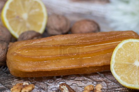 Téléchargez les photos : Gâteau sucré turc appelé tulumba, servi dans une assiette avec des tranches de citron et de noix autour, sur une table en bois massif - en image libre de droit