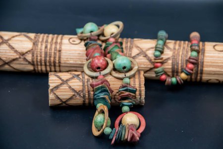 Collar tradicional tribal colorido, expuesto en instrumento musical de madera hecho a mano tribal