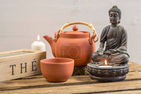 Téléchargez les photos : Temps de thé nature morte dans le pur style asiatique avec tasses à thé en céramique brune, pot et statue de Bouddha avec bougie - en image libre de droit