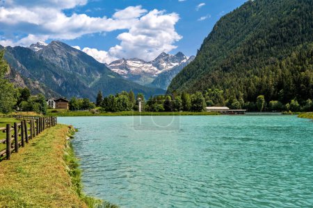 View of small alpine Lake Brusson and mountains under beautiful sky on background in Aosta Valley, Italy.