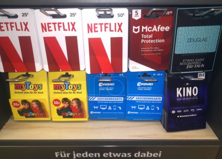 Photo for WETZLAR, HESSE, GERMANY 03-14-2022: Netflix, McAfee, Douglas, myToys, and Conrad gift cards for sale on a display rack ready for purchase - Royalty Free Image