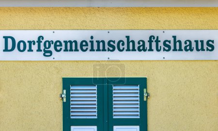Village Community Center Sign on a yellow house facade in germany.
