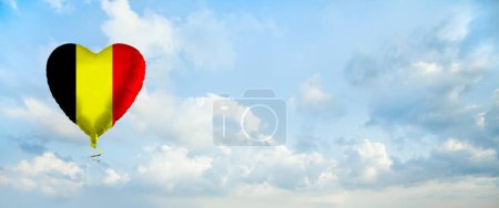 Foto de Bandera de Bélgica sobre globo en forma de corazón sobre fondo de nubes de cielo. Educación, caridad, emigración, viajes y aprendizaje. Bélgica concepto de idioma - Imagen libre de derechos
