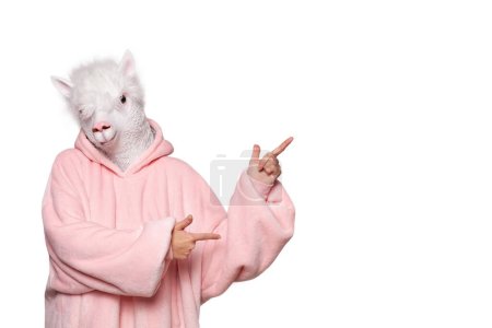 Portrait of creative person in pink hoodie with lama mask pointing up isolated on white