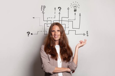 Photo for Smiling brunette woman with arrows, light bulb, question marks above her head. Idea, brainstorming, business stratgy, thinking concept - Royalty Free Image