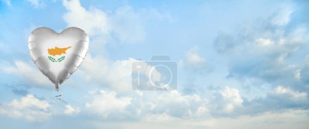 Foto de Flag of Cyprus on heart-shaped balloon against sky clouds background. Education, charity, emigration, travel and learning. Cyprus language concept - Imagen libre de derechos