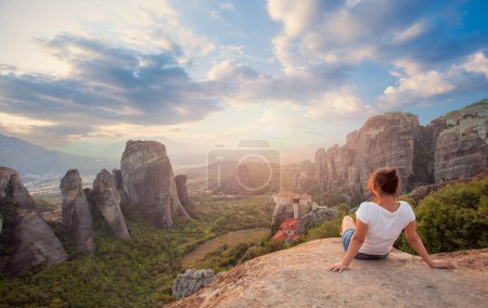 Photo for Woman overlooking the rockformations of meteora at sunset - Royalty Free Image