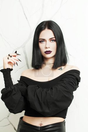 Photo for Nice brunette goth woman with black nails on white background - Royalty Free Image