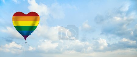 Téléchargez les photos : Drapeau LGBT sur ballon en forme de cœur sur fond de nuages du ciel. - en image libre de droit