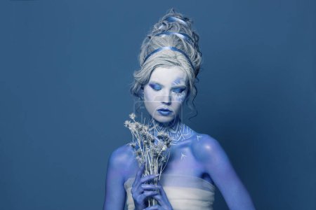 Young Snow Queen woman portrait. Beautiful female model with creative makeup. Carnival or Halloween party concept