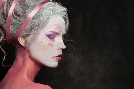Téléchargez les photos : Gros plan visage féminin avec magie fantaisie maquillage sur fond noir - en image libre de droit