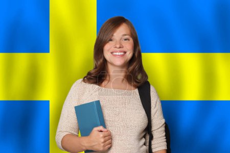 Cheerful woman student against Swedish flag background. Travel, education and learn language in Sweden concept
