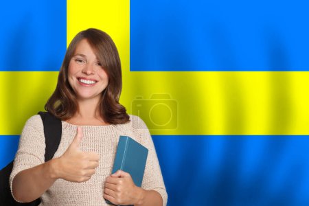 Happy woman student against Swedish flag background. Travel, education and learn language in Sweden concept