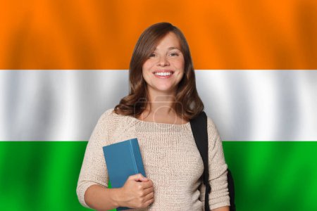 Glückliche Studentin vor indischem Flaggenhintergrund. Reisen, Bildung und Spracherwerb in Indien