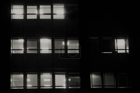 Photo for Office building facade windows with venetian blinds at night. - Royalty Free Image