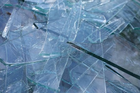 Shards of glass transparent broken pieces abstract material background.