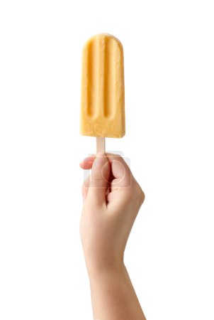 Photo for Woman hand holding yellow fruit popsicle isolated on white background. Mango, pineapple and orange flavor - Royalty Free Image