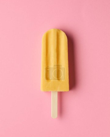 Foto de Paleta de fruta amarilla sobre fondo rosa, vista superior. Mango, fruta de la pasión y sabor a piña - Imagen libre de derechos